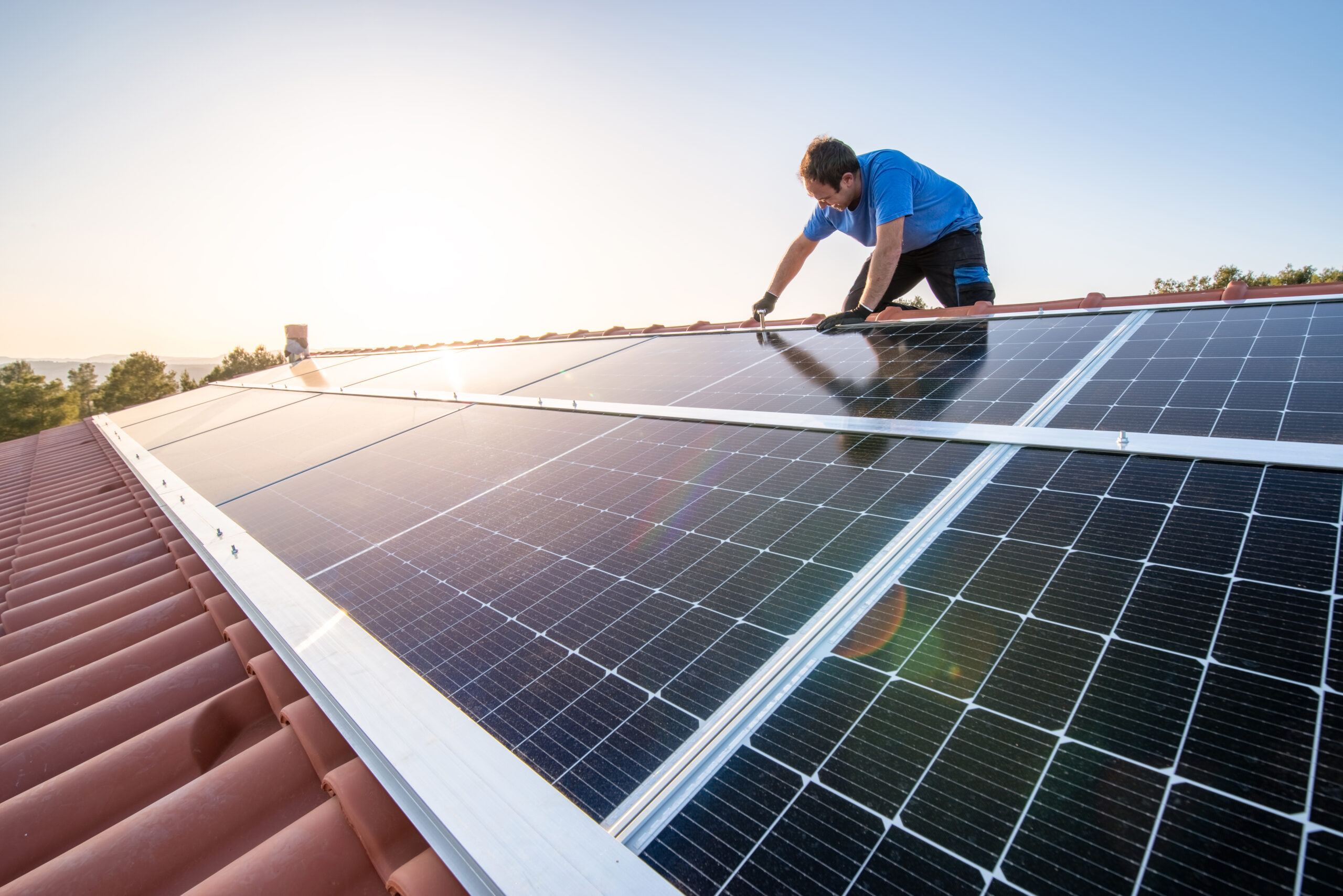 Professional worker installing solar panels on the roof of a house