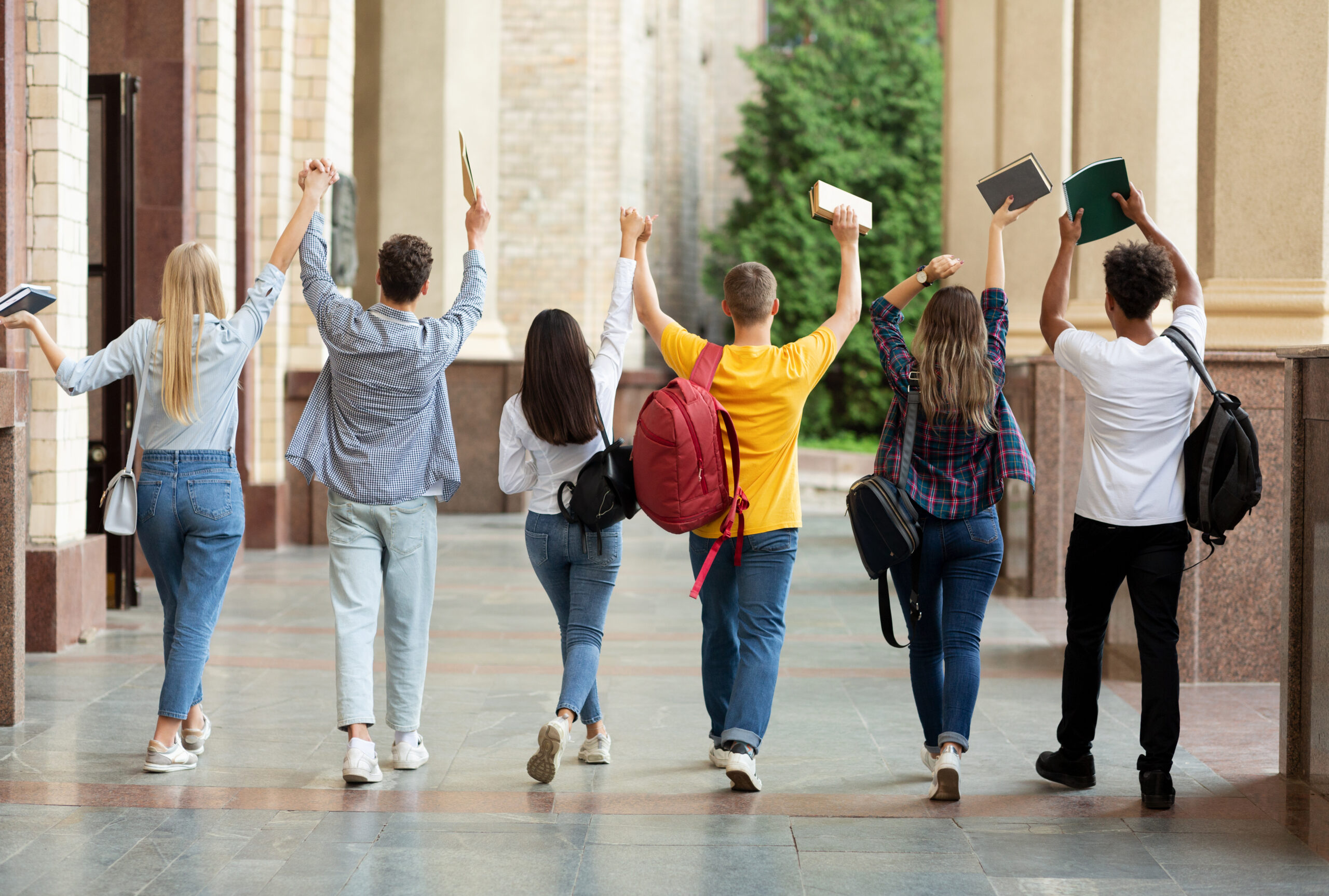 We passed exams Students raised hands and walking in campus