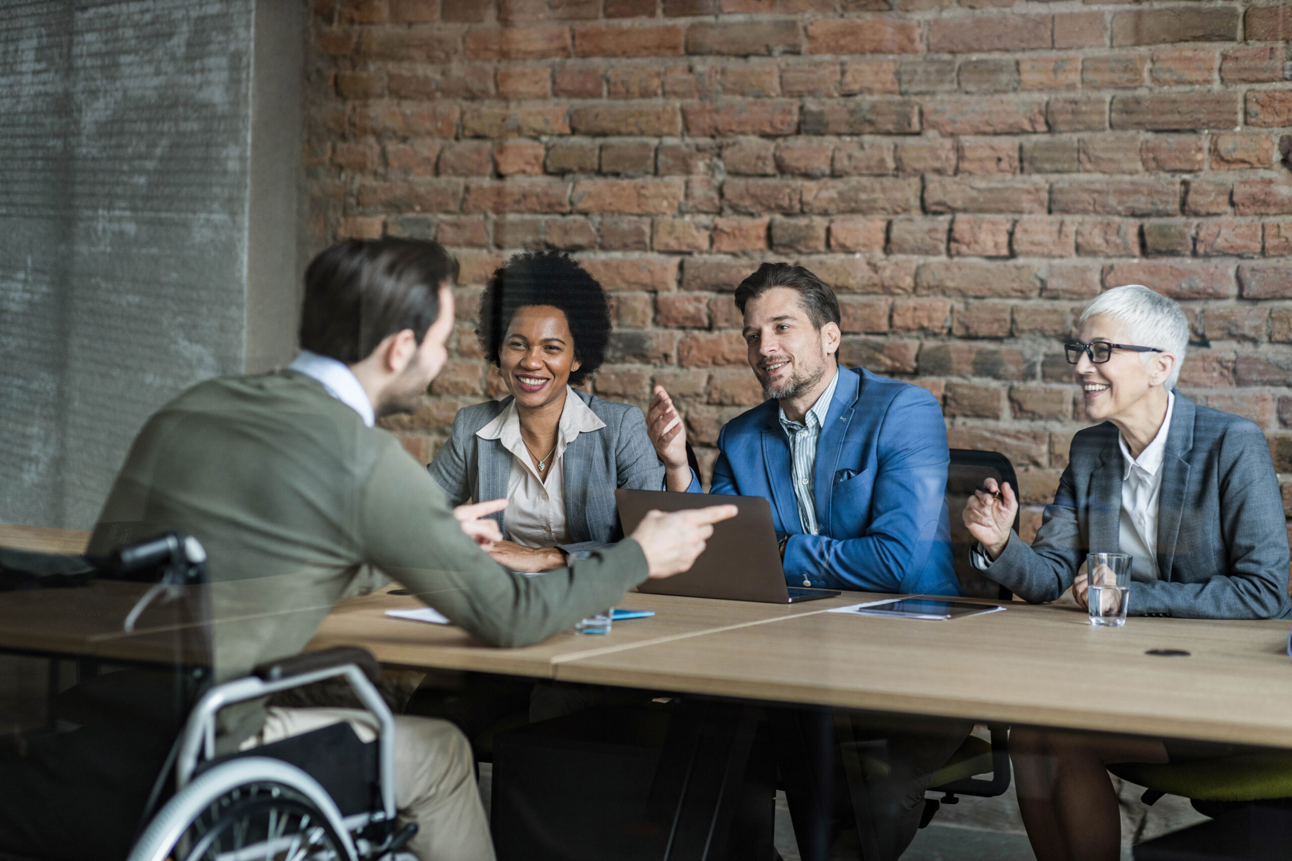 Happy human resource team talking to disabled candidate