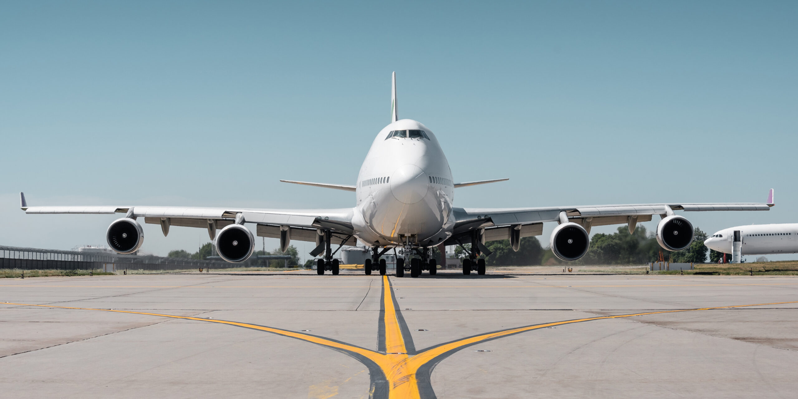 Huge white passenger aircraft taxiing on a sunny day,