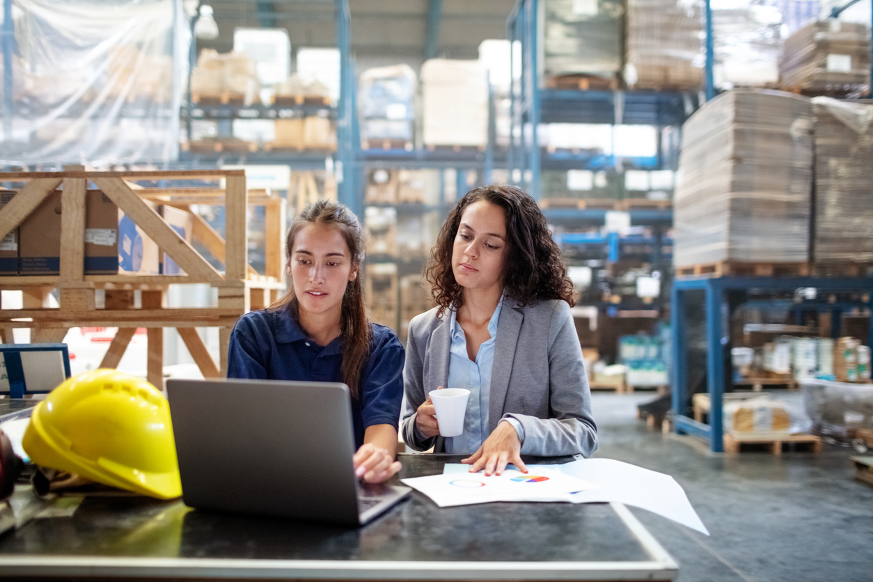 Warehouse workers checking the stocks on laptop