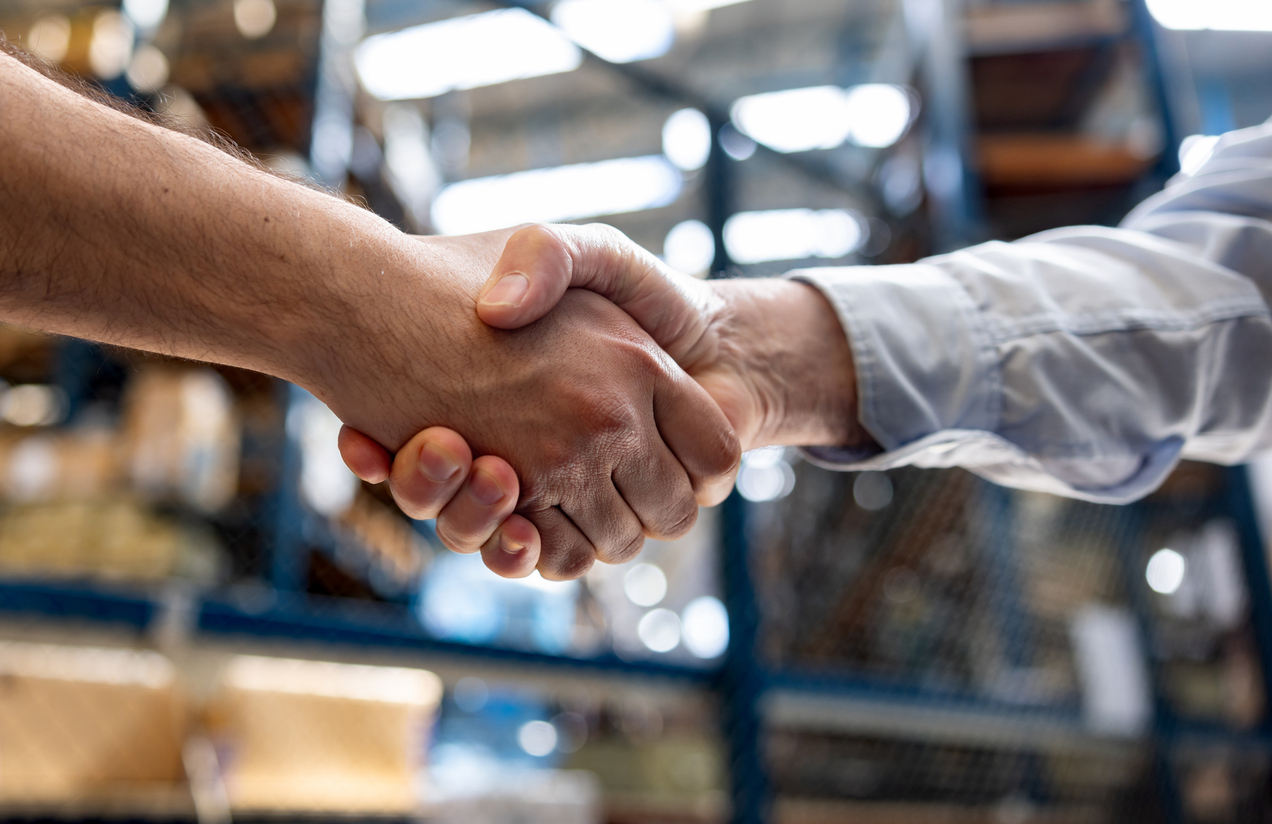 Warehouse manager hiring an employee and handshaking his hand