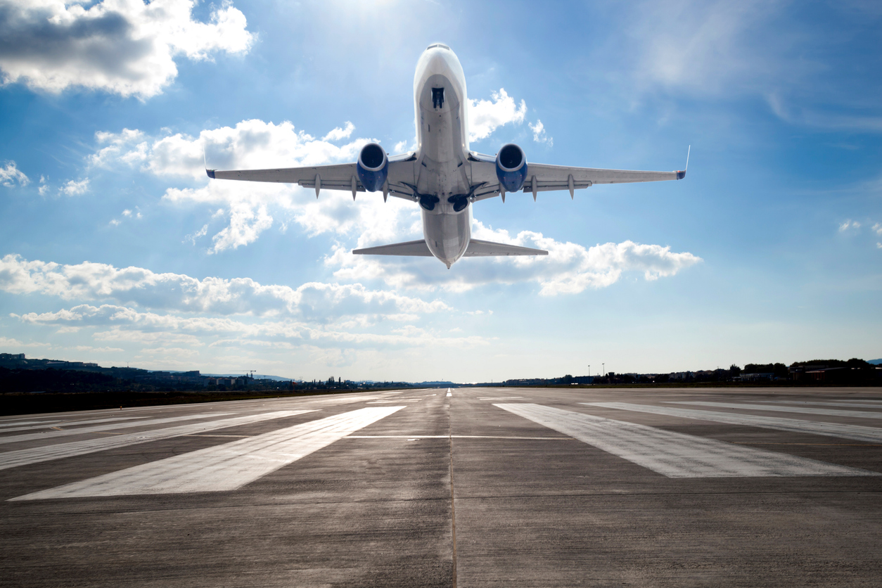 Passenger airplane taking off at sunset