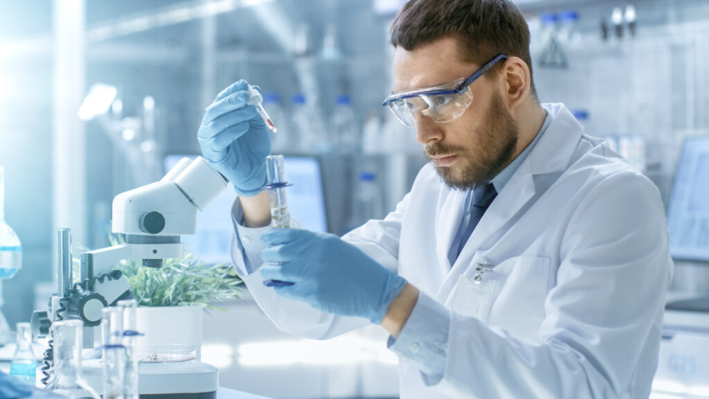 In a Modern Laboratory Scientist Conducts Experiments by Synthesising Compounds with use of Dropper and Plant in a Test Tube