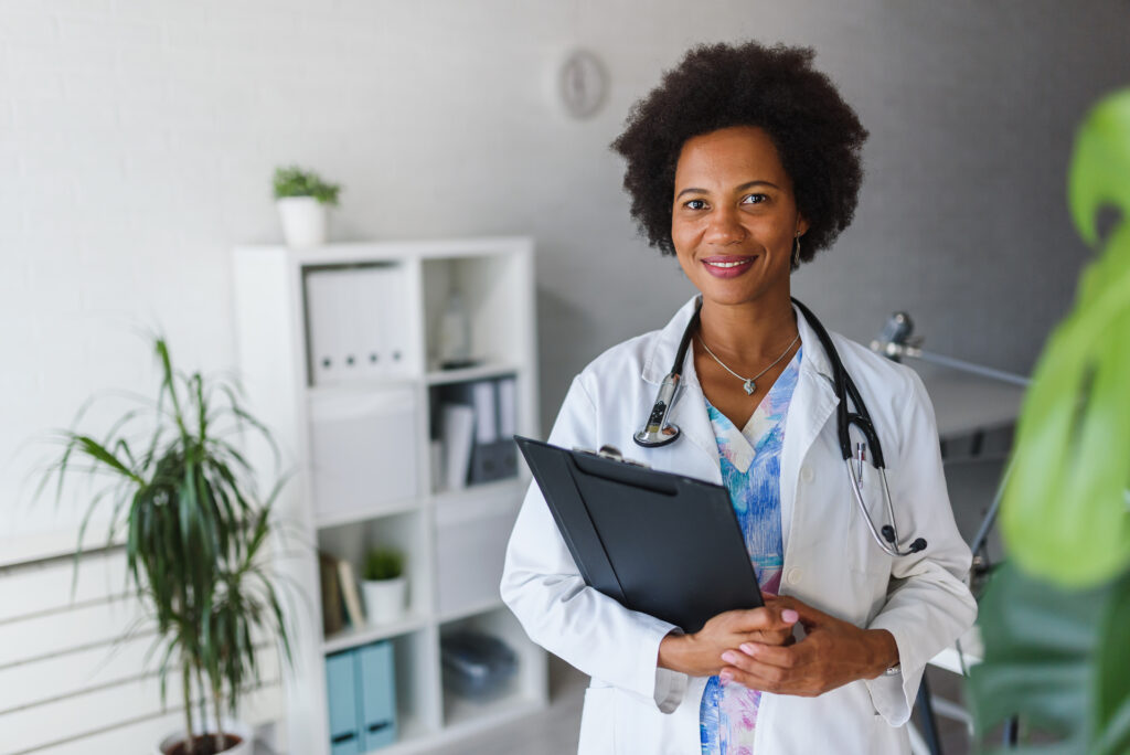 Portrait of female African American doctor standing in her office at clinic